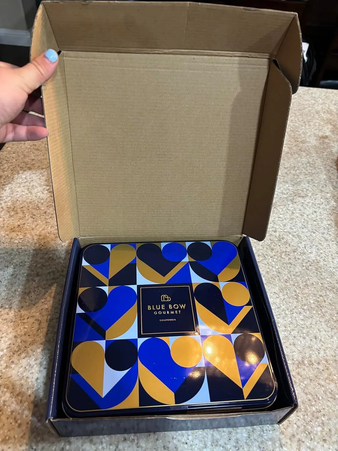 Customer photo of opened gourmet cookie box showing assorted cookies arranged inside with packaging