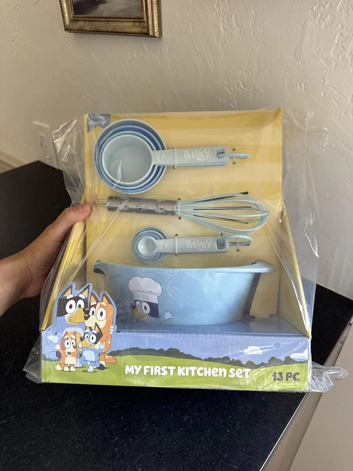 Customer photo of child's hands mixing cookie dough in a bowl with baking tools